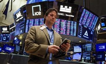  Một nhà giao dịch cổ phiếu trên sàn NYSE ở New York hôm 22/6 - Ảnh: Reuters.