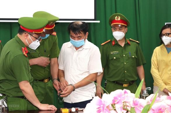 Cảnh sát bắt ông Nguyễn Trần Tuấn (áo trắng). Ảnh: TTXVN
