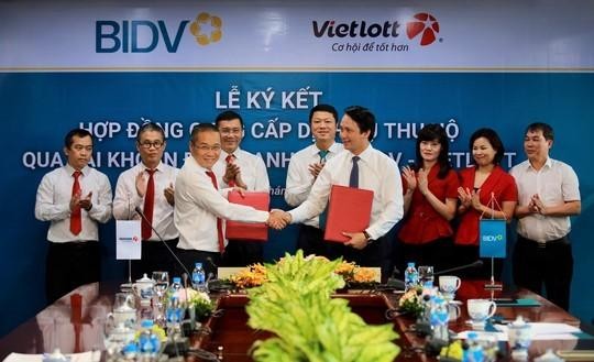 Ông Trần Long - Phó Tổng Giám đốc BIDV (bên phải) và ông Võ Quang Vinh - Phó Tổng Giám đốc Vietlott, đại diện hai bên ký kết hợp đồng