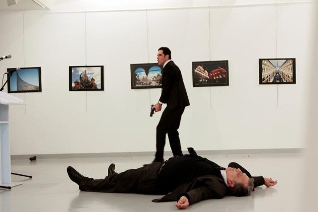 Đại sứ Nga tại Thổ Nhĩ Kỳ Andrei Karlov nằm sõng soài trên sàn sau khi bị một kẻ lạ mặt tấn công từ phía sau tại một triển lãm ở Ankara hôm 19/12. (Ảnh: Reuters)