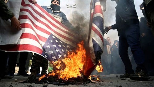 Người biểu tình tại Iran đốt cờ Mỹ và Anh sau khi tướng Qassem Soleimani bị giết.Ảnh: Reuters