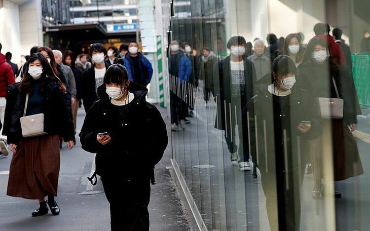 Người Nhật Bản đeo khẩu trang bên ngoài một nhà ga ở Yokohama. Ảnh:Reuters