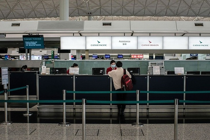 Nhân viên của Cathay Pacific nói chuyện với một hành khách tại sân bay quốc tế Hong Kong vào tháng 2/2020.Ảnh: Bloomberg