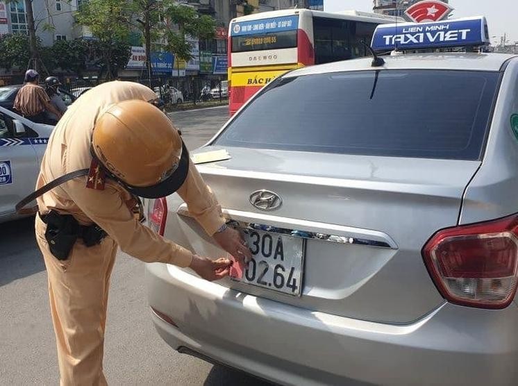 CSGT Hà Nội xử lý tài xế ô tô taxi che biển số trên đường Giải Phóng. Ảnh: TCGT